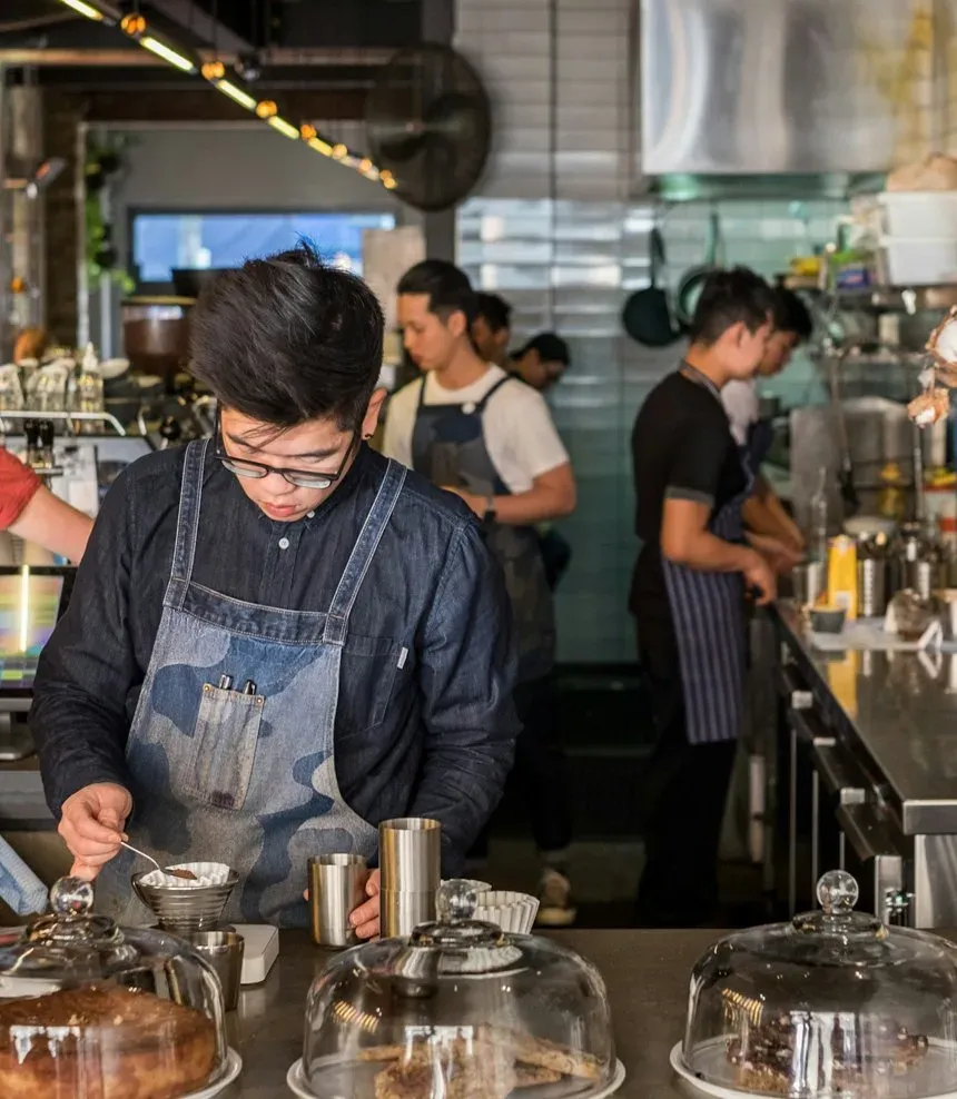 Baristas working a busy espresso bar during the morning rush