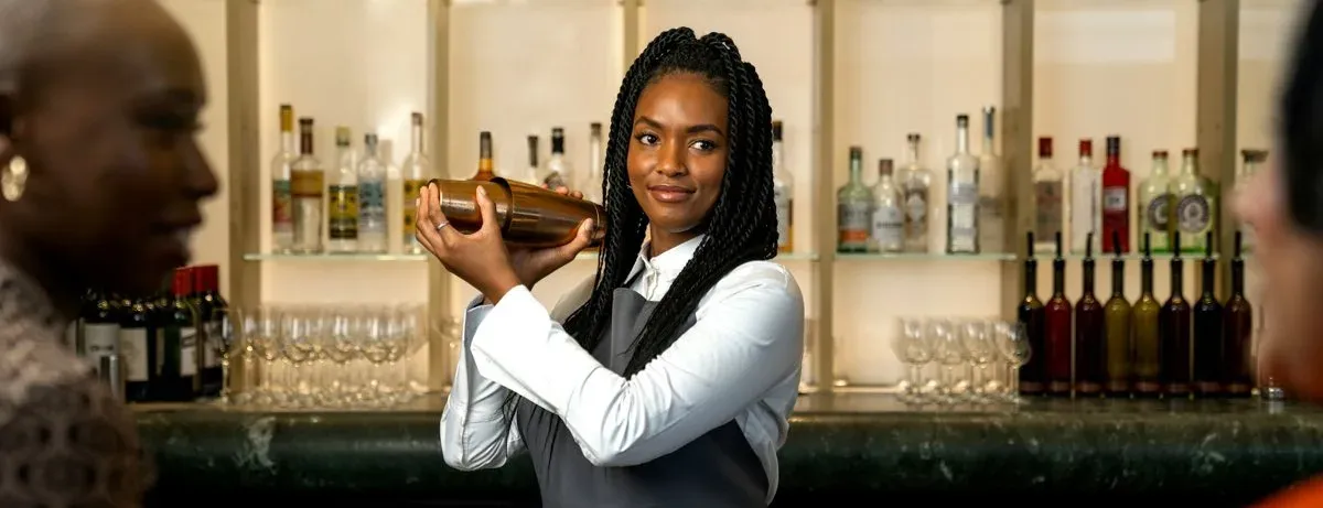 Bartender shaking a cocktail for guests at the bar