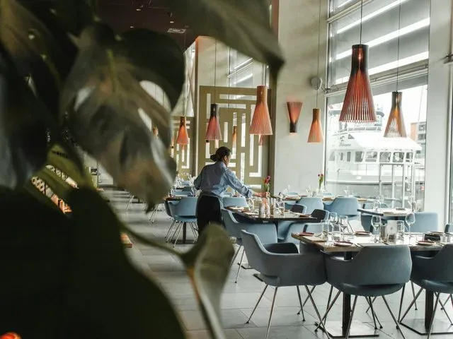 Restaurant server setting tables in a waterfront dining room