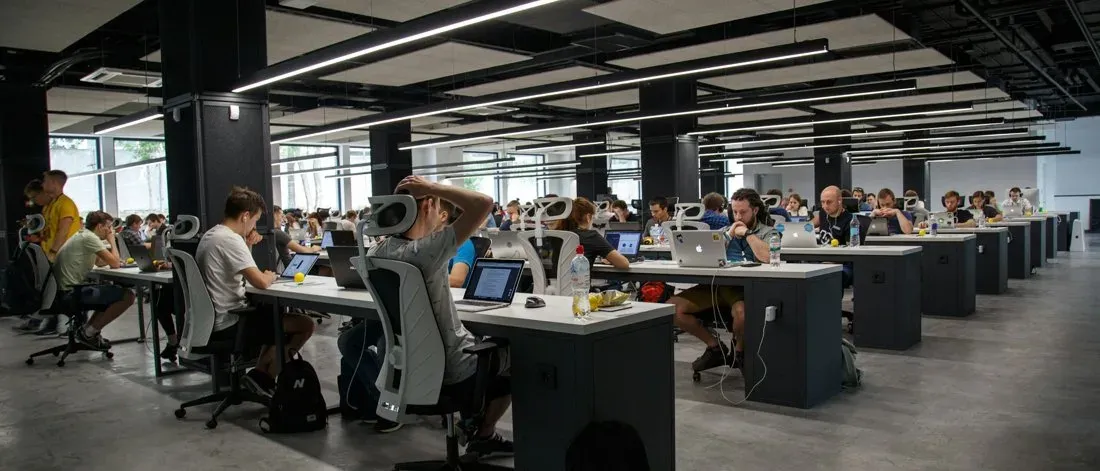 A large open-plan office full of desks, illustrating the volume of applicants a recruiting team must screen